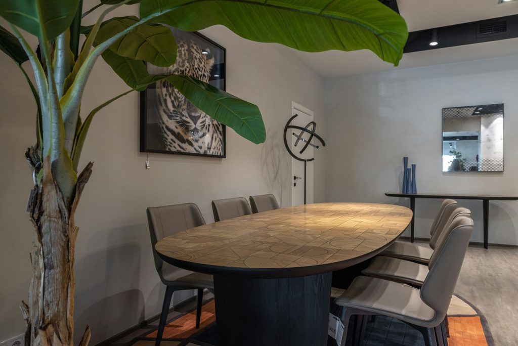 Team in vergaderruimte voert productieve goede vergadering, met deelnemers die elkaar kunnen zien en samen aan een tafel zitt